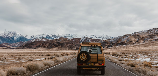 Campervan fährt durch bergige Landschaft